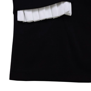 Detail of black and white contrast fabric with fine accordion pleats and stitching