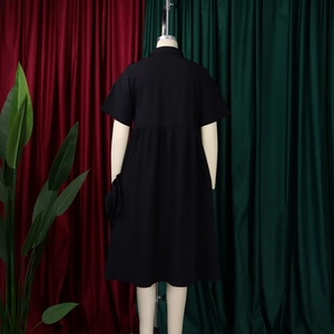 Detailed back view of a black short-sleeved A-line dress with high waist and pleated hem