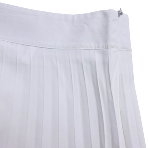 Close-up of white pleated wide-leg pants featuring a concealed side zipper and twill fabric