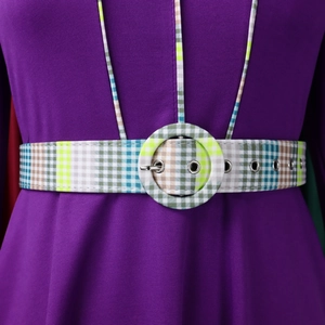 Detail of purple knit dress featuring vintage plaid belt with round covered buckle