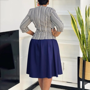 Vue arrière d'un ensemble blazer à carreaux et jupe plissée bleu marine pour femme