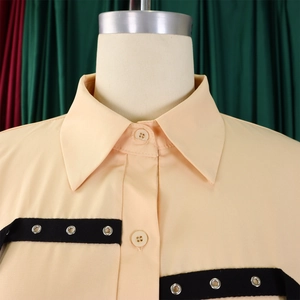 Detail of short sleeve shirt collar with black webbing trim and silver metal eyelets