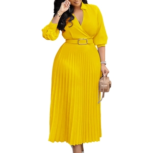 Detailed view of yellow pleated dress featuring a V-neckline and elegant gold buckle belt