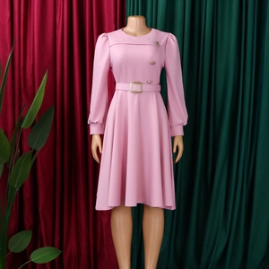 Dettaglio dell'abito rosa a maniche lunghe con bottoni metallici e cintura coordinata