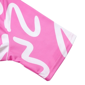 Macro detail of short sleeve cuff featuring pink and white wave print with neat stitching