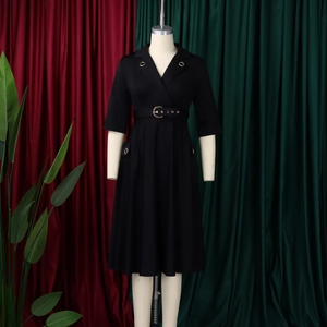 Détail d'une robe blazer noire avec boucle dorée à la taille et col orné de métal élégant