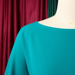 Dettaglio ravvicinato dell'abito a pieghe in chiffon verde acqua con scollo elegante
