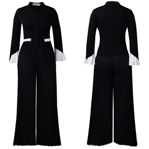 Detail of black wide-leg trousers and blazer with white pleated flare sleeves and trim