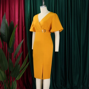 Detail of V-neck wrap dress with gold buckle belt and front slit in yellow fabric