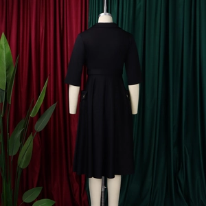 Vue arrière d'une robe mi-longue noire élégante avec boutons dorés et taille ceinturée