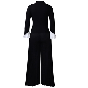 Detail of bell sleeves with white pleated ruffles on a black wide-leg two-piece set