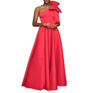 Macro shot of the oversized shoulder bow detail on a red satin one-shoulder evening gown