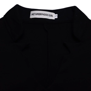 Detail of the V-neck lapel and brand label on a black wide-leg pants set top