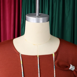 Detail view of the elegant round neck dress with color-block piping and bow embellishment