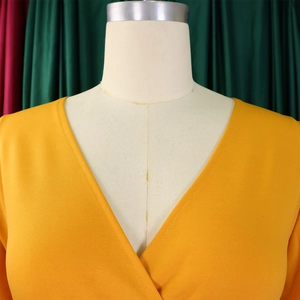 Detailed view of ginger yellow V-neck dress showing fine fabric texture and neat stitching
