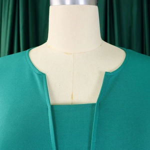 Détail d'une robe verte émeraude à manches courtes avec col en V et texture tricotée