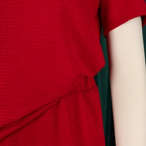 Détail du tissu rouge gaufré et de la taille cintrée sur un ensemble deux pièces chic
