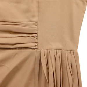 Detail of khaki A-line dress showing pleat construction and refined stitching quality