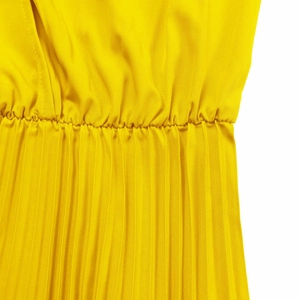 Detail of elastic pleated waist and accordion folds on bright yellow V-neck maxi dress