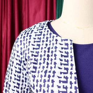 Détail du haut à col rond bleu marine et du cardigan à imprimé géométrique sur mannequin