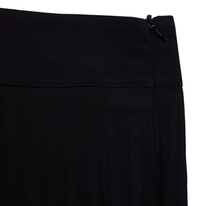 Detail of black wide-leg trousers with precise stitching and a hidden side zipper closure