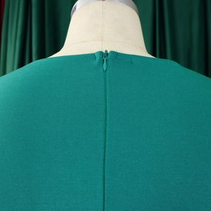 Gros plan sur la fermeture éclair invisible et le tissu d'une robe verte élégante