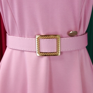Dettaglio dell'abito rosa a trapezio con cintura in tessuto e fibbia quadrata dorata incisa