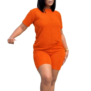 Détail de l'ensemble orange avec un tissu à texture plissée en 3D et un short de cyclisme