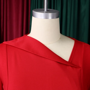 Detailed close-up of the asymmetrical overlapping neckline on this red fashion dress