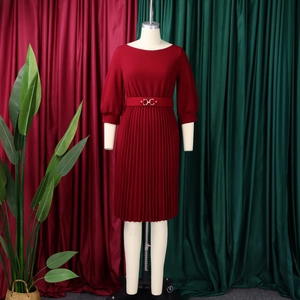 Dettaglio dell'abito a pieghe rosso scuro elegante con maniche a 3/4 e cintura su manichino