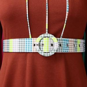 Detail of burgundy dress featuring a colorful plaid belt with a round buckle and silver eyelets