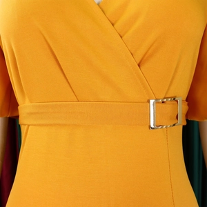 Detail of yellow V-neck dress featuring a textured fabric and a gold rectangular waist buckle