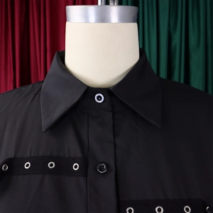 Detail shot of black lapel shirt showing silver eyelet strap and button closure