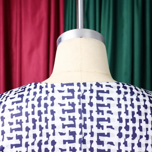 Détail du décolleté arrière de la robe blanche à imprimé géométrique sur mannequin