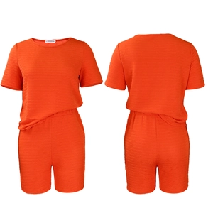Détail du tissu texturé orange de l'ensemble haut à manches courtes et short assorti