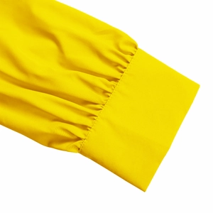 Detail of elegant pleated cuffs on a yellow long-sleeved dress with premium fabric texture
