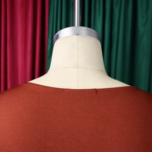 Close-up of brick red knit dress neckline with elegant horizontal ribbed texture