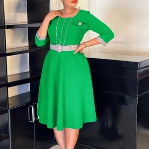 Detail of green dress with bow accent, checkered cuffs, and matching waist belt
