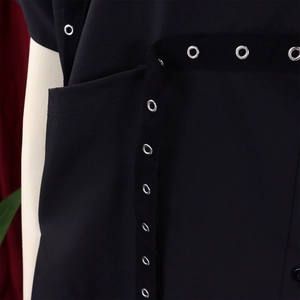 Close-up of black shirt with industrial eyelet ribbon detail and side pocket
