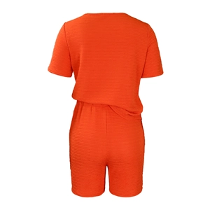 Vue arrière de l'ensemble de détente orange avec haut plissé à manches courtes et short assorti