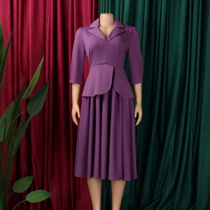 Détail d'un tailleur violet avec col blazer, ourlet à volants et jupe plissée midi