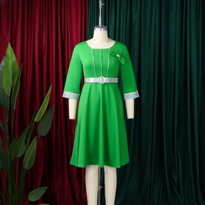 Detailed view of green dress featuring plaid ribbon accents and elegant waist buckle
