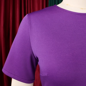 Dettaglio di un abito viola scuro a maniche corte con girocollo in maglia pregiata