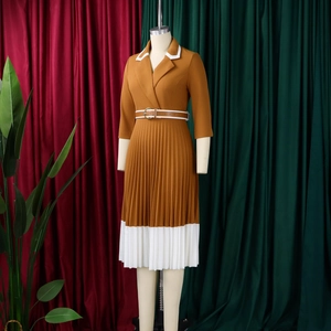 Detail of a brown A-line dress with white pleated hem and matching waist belt