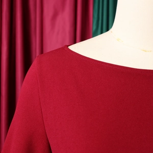 Dettaglio del colletto e della spalla di un abito elegante in chiffon rosso con pieghe fini