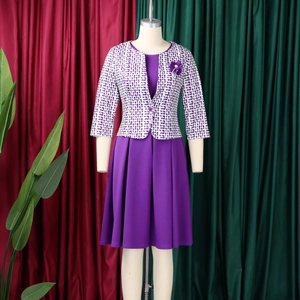 Détail de l'ensemble robe violette avec cardigan à motifs et broche fleur en satin