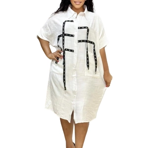 Detail of white shirt dress with black polka dot ribbon trim and button-down front