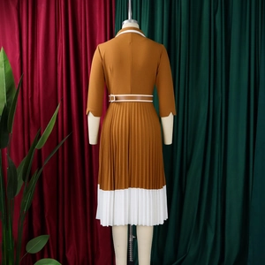 Detailed view of the ginger brown dress with white pleated hem and adjustable waist belt