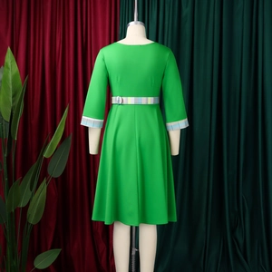 Detail of green dress featuring plaid patchwork cuffs and a matching waist belt on a mannequin