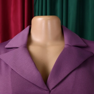 Détail du revers en pointe et de la texture de ce blazer violet à manches trois-quarts